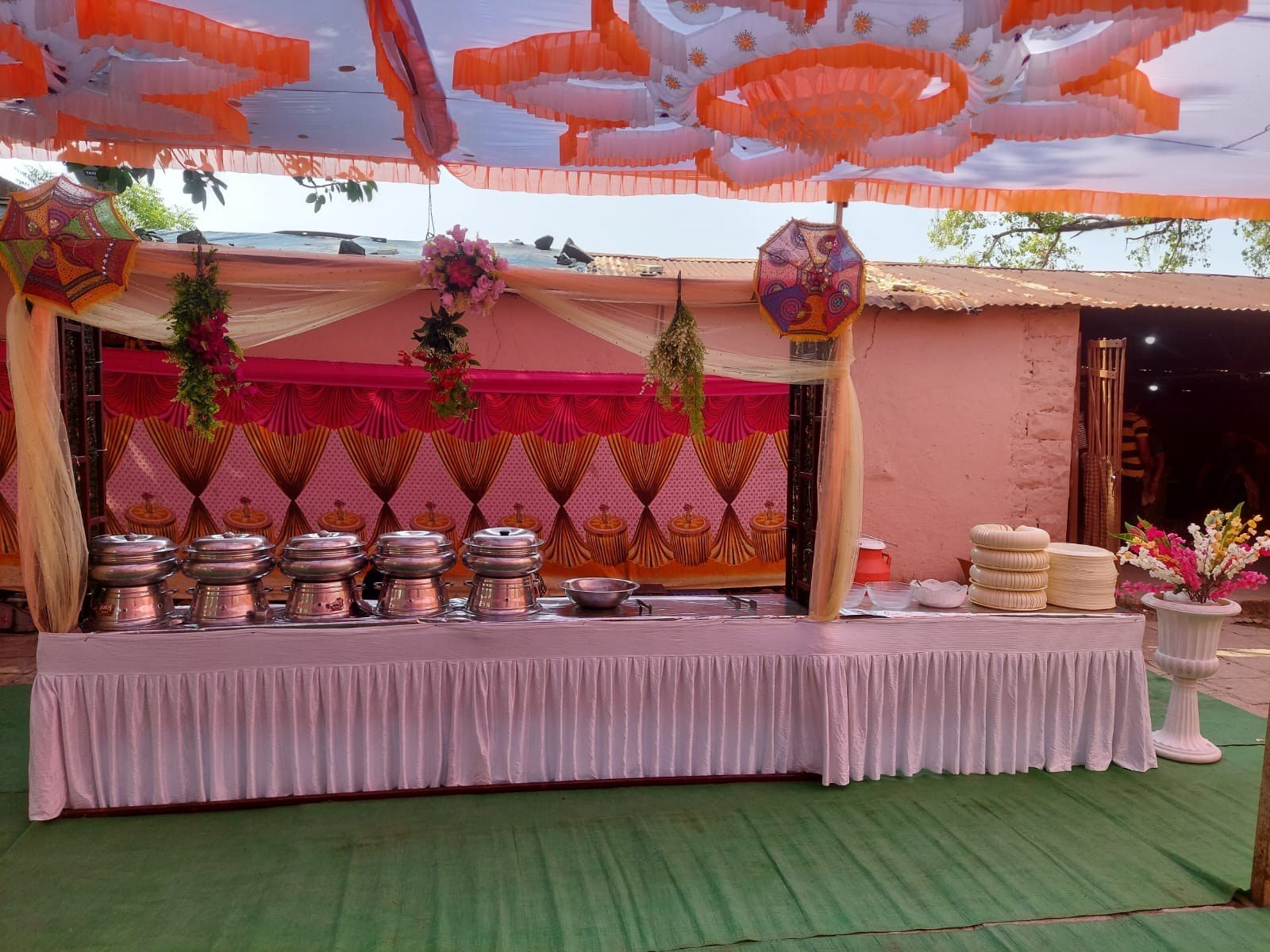 Buffet counter with chafing dishes under a decorated canopy