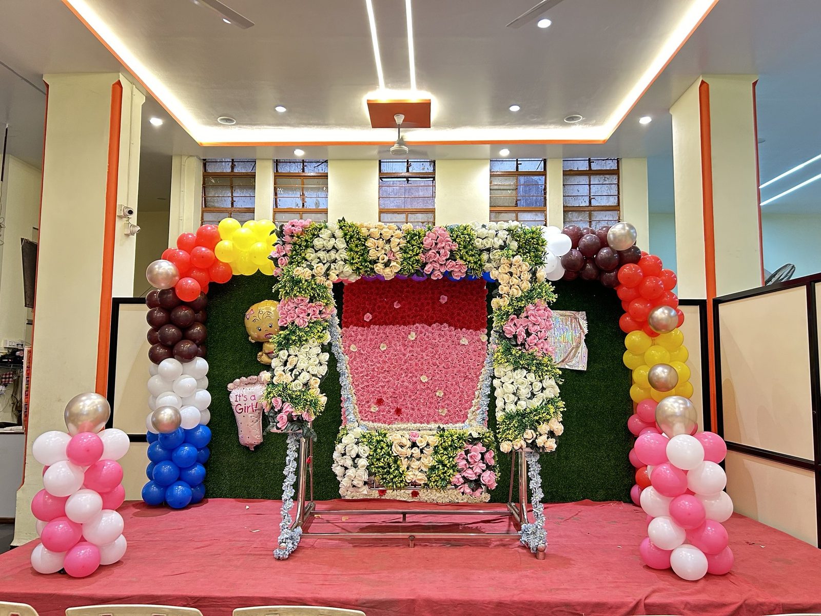 Flower and balloon decoration around a cradle for a naming ceremony
