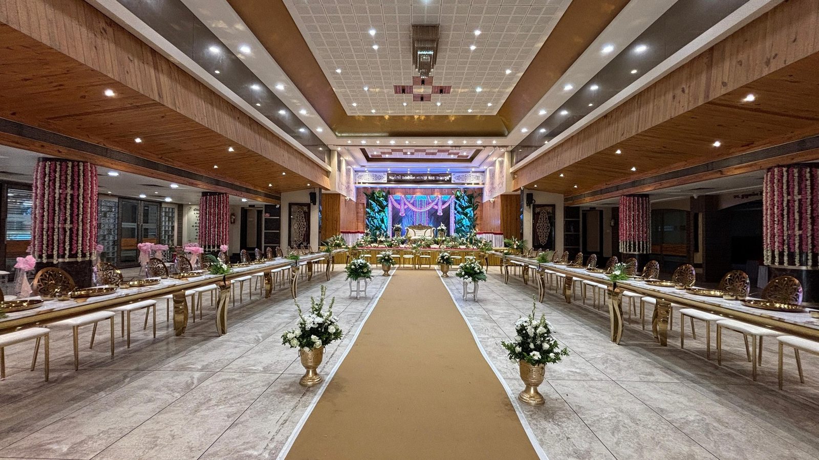 Long dining tables set out in a hall ahead of the guests